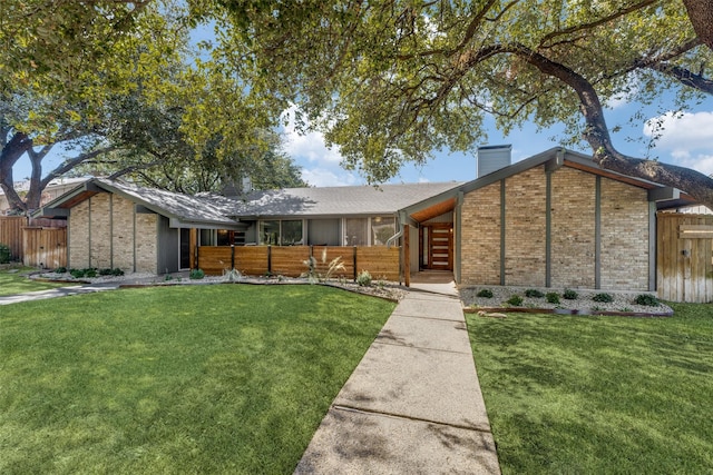 mid-century inspired home with a chimney, fence, and a front yard