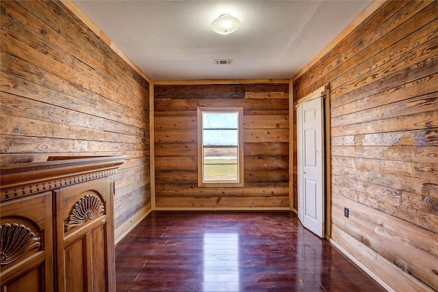 unfurnished room with visible vents and dark wood-style flooring