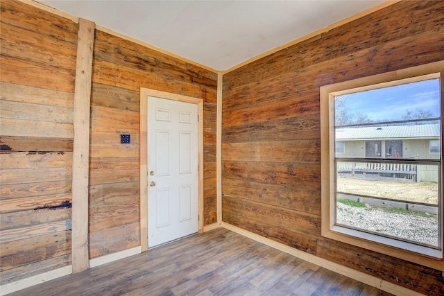 unfurnished room featuring wood finished floors and wooden walls