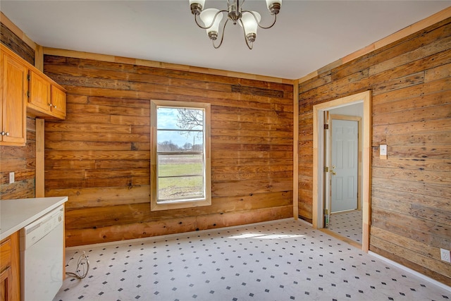 interior space with a chandelier, wood walls, and light colored carpet