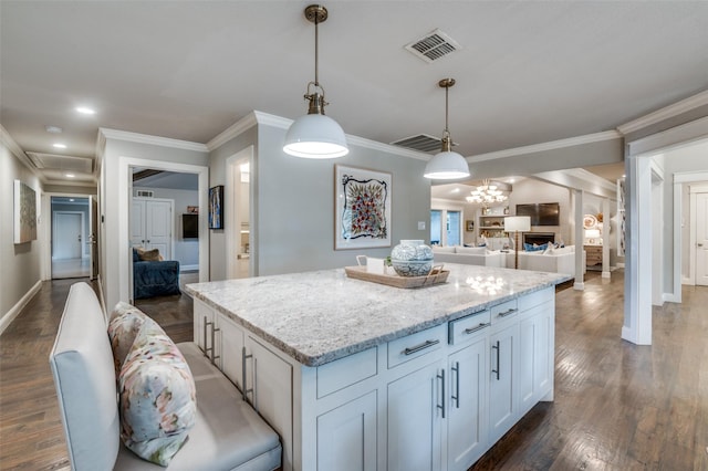 kitchen with ornamental molding, a center island, visible vents, and dark wood finished floors