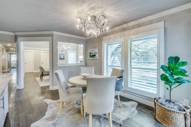 dining area with crown molding, dark wood-type flooring, baseboards, and an inviting chandelier