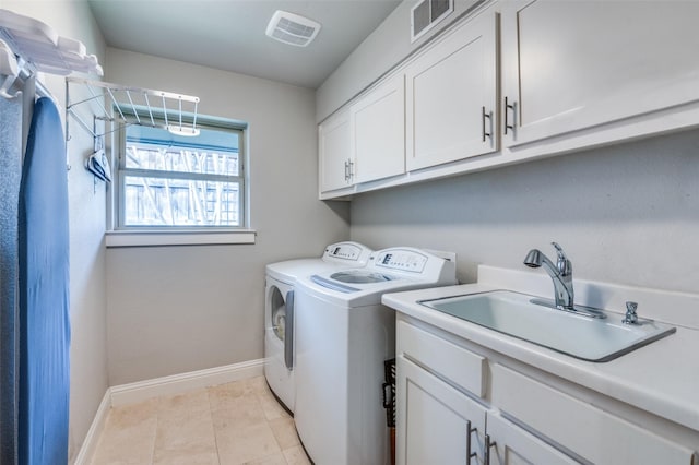 laundry area featuring visible vents, washing machine and clothes dryer, a sink, and cabinet space