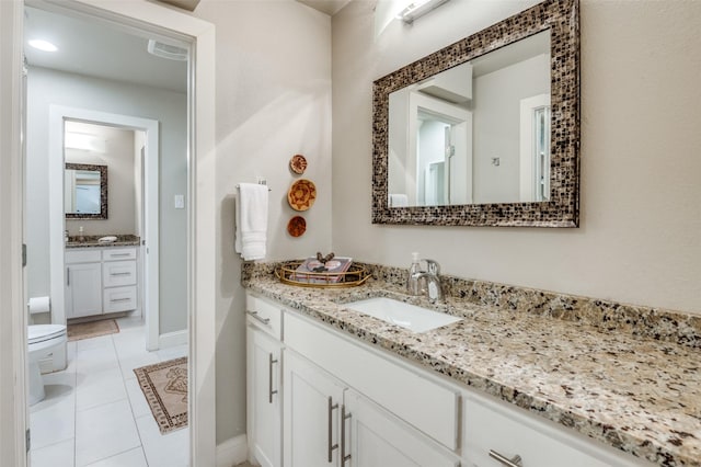 bathroom featuring toilet, tile patterned flooring, vanity, and baseboards