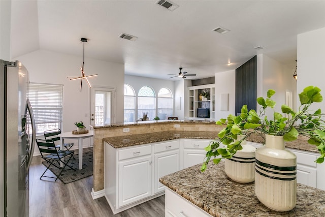 kitchen featuring white cabinets, plenty of natural light, visible vents, and stainless steel refrigerator with ice dispenser