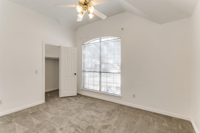 unfurnished bedroom featuring lofted ceiling, multiple windows, carpet, and baseboards