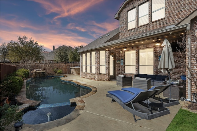 pool at dusk featuring a fenced in pool, a fenced backyard, and a patio area