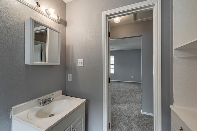 bathroom with a textured wall and vanity