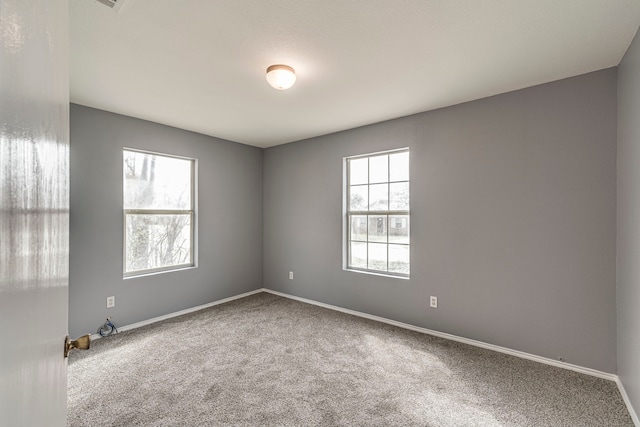 empty room featuring carpet flooring and baseboards