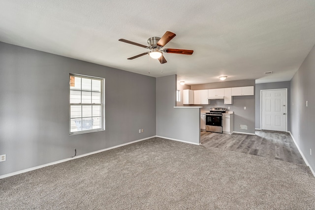 unfurnished living room featuring visible vents, light carpet, ceiling fan, a textured ceiling, and baseboards