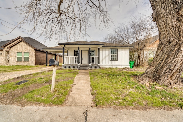 bungalow-style house with a carport, covered porch, driveway, and board and batten siding