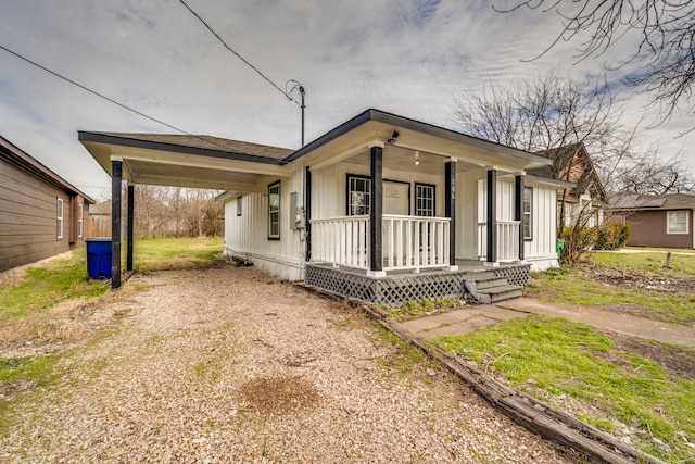 view of front of house with a carport, driveway, and a porch