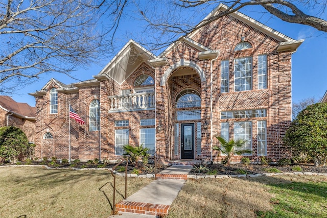 traditional-style home with a front yard and brick siding