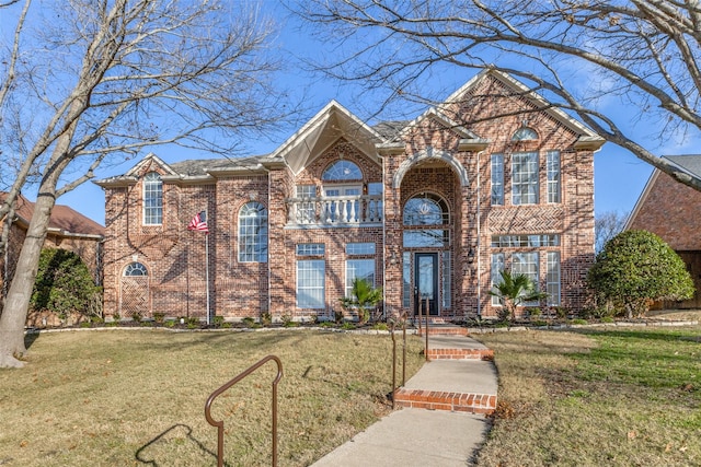 traditional-style house featuring a front yard and brick siding