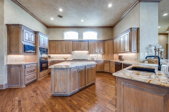 kitchen with visible vents, dark wood-type flooring, a sink, light stone counters, and built in microwave