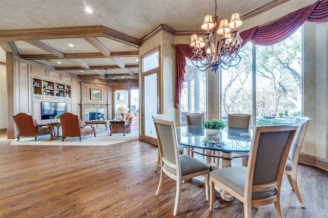 dining area with a healthy amount of sunlight, coffered ceiling, crown molding, and wood finished floors