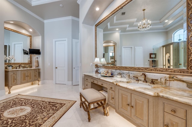 full bathroom featuring two vanities, a sink, crown molding, a raised ceiling, and a notable chandelier