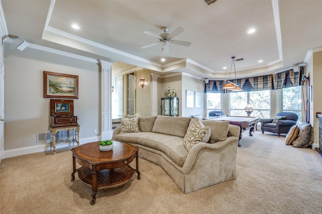 living area featuring a tray ceiling, carpet flooring, decorative columns, baseboards, and ceiling fan