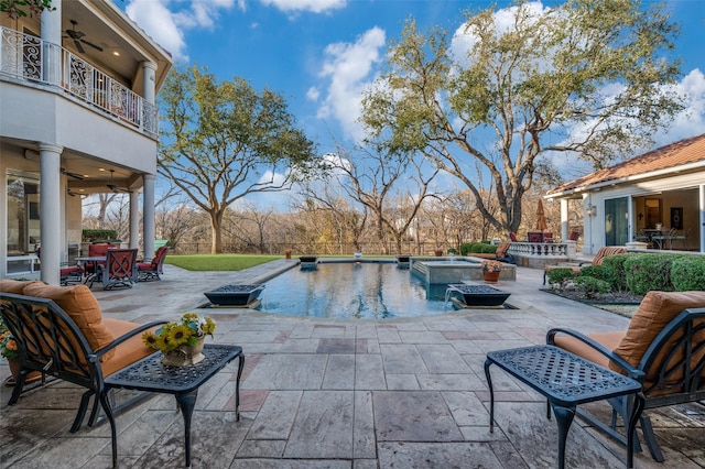 outdoor pool featuring an in ground hot tub, outdoor dining area, a ceiling fan, and a patio area