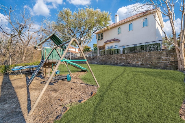 view of playground featuring a yard and fence