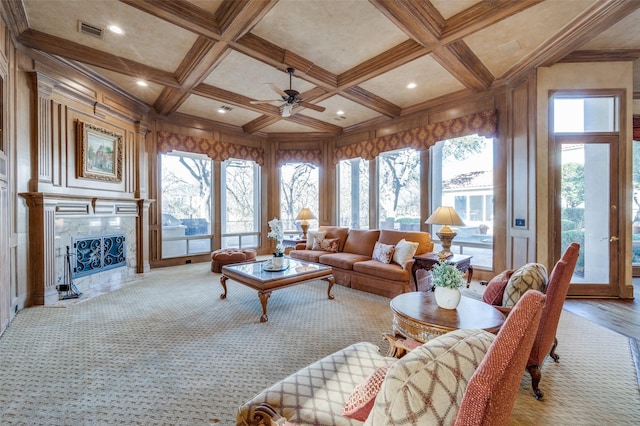 living area with visible vents, beam ceiling, coffered ceiling, a high end fireplace, and ceiling fan