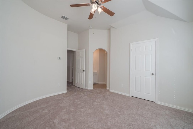 unfurnished bedroom with arched walkways, lofted ceiling, visible vents, baseboards, and carpet