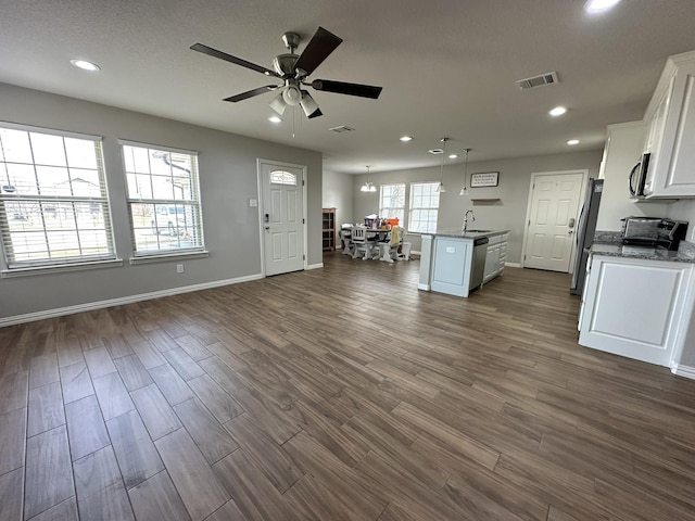 kitchen with visible vents, open floor plan, dark wood-type flooring, stainless steel appliances, and white cabinetry