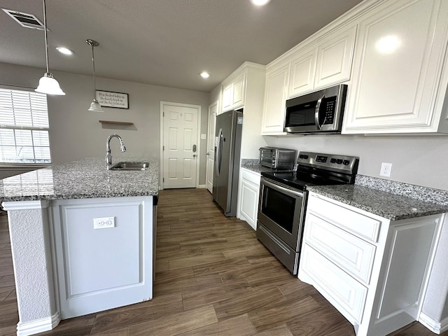 kitchen with visible vents, appliances with stainless steel finishes, dark wood-type flooring, white cabinets, and a sink