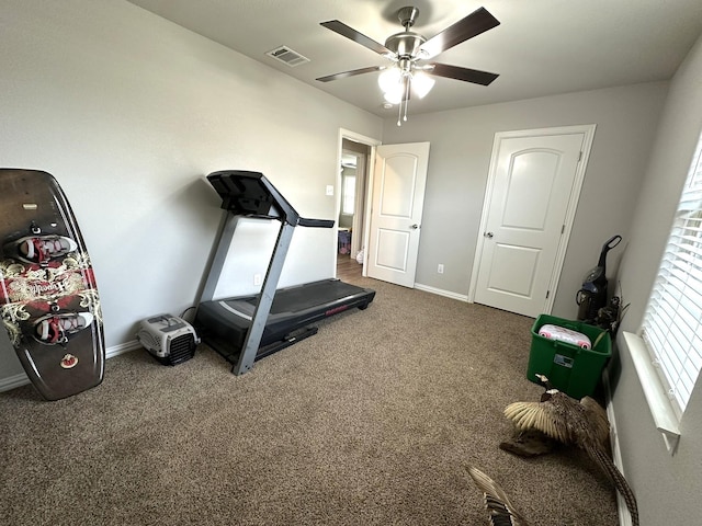 workout area with carpet flooring, ceiling fan, visible vents, and baseboards