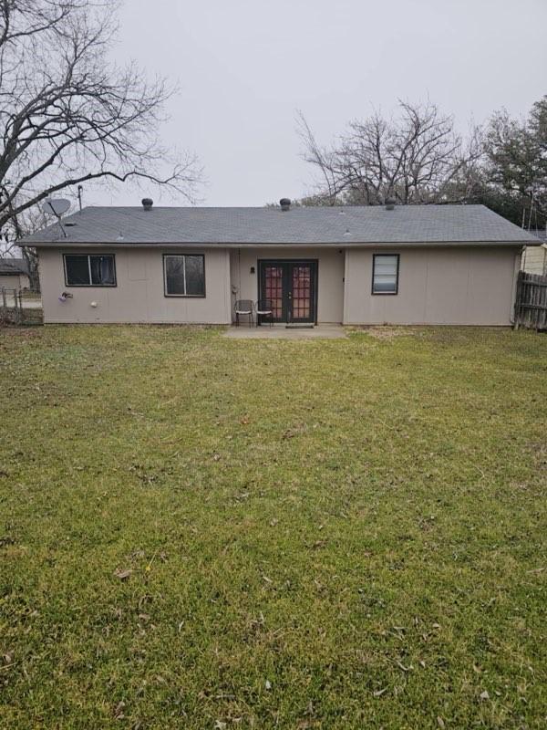 back of property featuring french doors, a patio area, a lawn, and fence