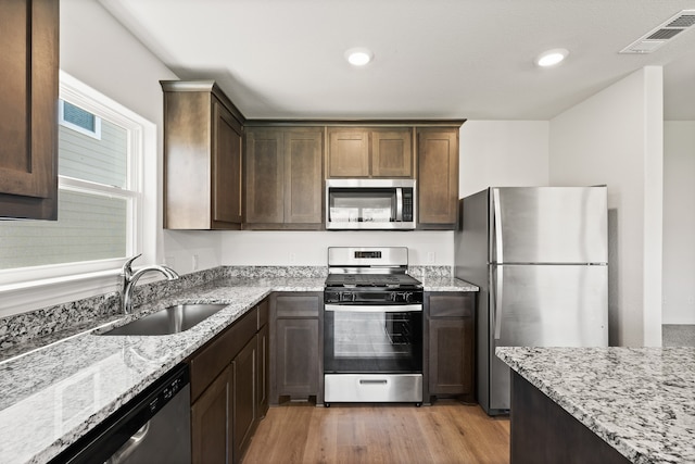 kitchen with visible vents, appliances with stainless steel finishes, light wood-style flooring, and a sink