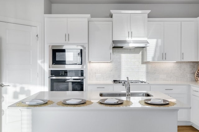 1536 Wolfberry Ln, Northlake, TX 76226 - kitchen featuring appliances with stainless steel finishes, under cabinet range hood, light countertops, and white cabinetry