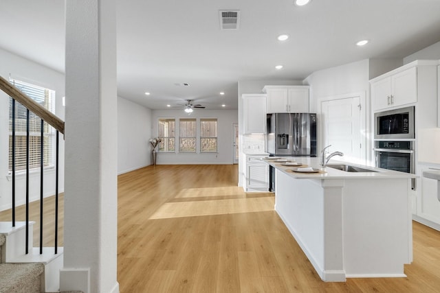 1536 Wolfberry Ln, Northlake, TX 76226 - kitchen featuring appliances with stainless steel finishes, a sink, recessed lighting, light wood-style floors, and white cabinets