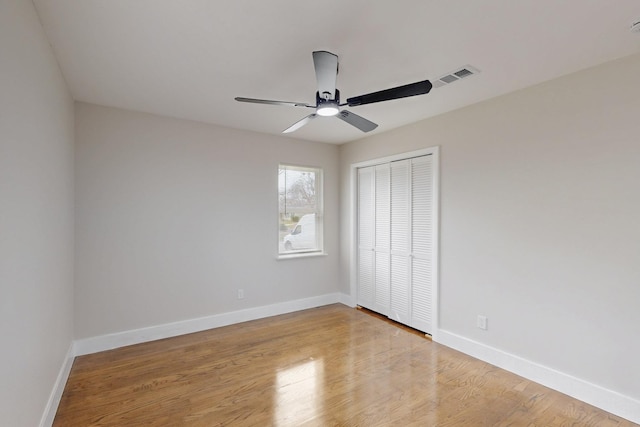 unfurnished bedroom featuring light wood-style floors, a closet, visible vents, and baseboards