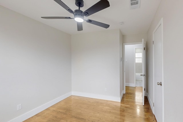 unfurnished room with a ceiling fan, light wood-type flooring, visible vents, and baseboards