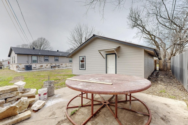 rear view of house featuring central AC unit, a lawn, a patio area, and fence