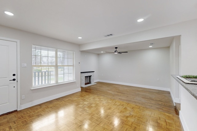 unfurnished living room featuring a brick fireplace, baseboards, and recessed lighting