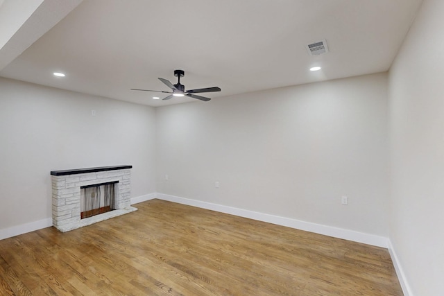 unfurnished living room with a fireplace, recessed lighting, visible vents, light wood-style floors, and baseboards