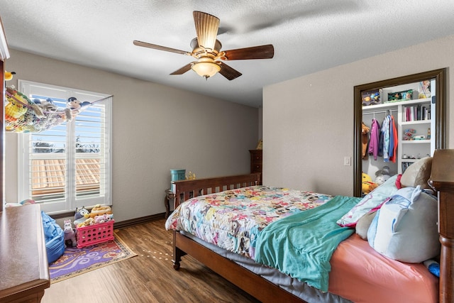 bedroom with a textured ceiling, wood finished floors, a ceiling fan, and baseboards