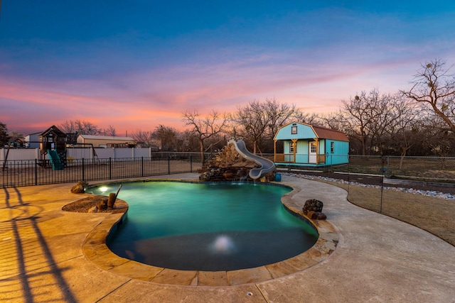 view of swimming pool with a fenced in pool, a playground, fence, and a water slide