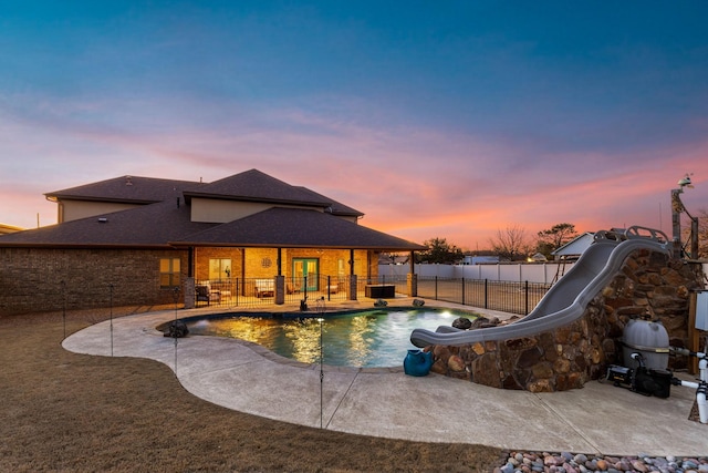 view of swimming pool with a patio, a water slide, a playground, a fenced backyard, and a fenced in pool