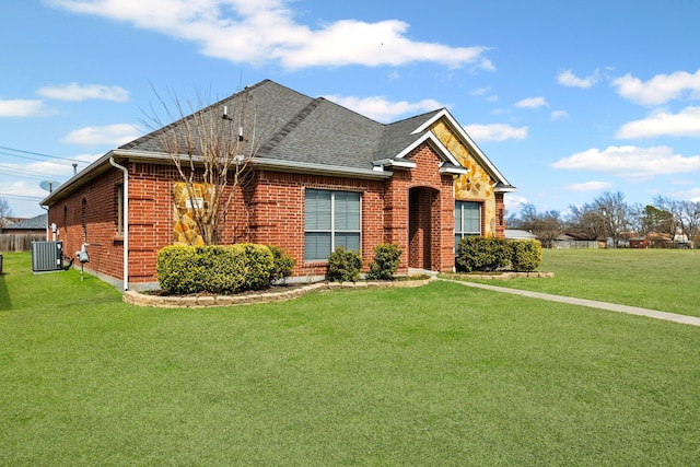 view of front of home featuring brick siding, central AC, a front lawn, and roof with shingles