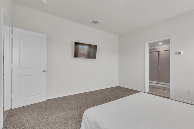 carpeted bedroom with ensuite bath, visible vents, and baseboards