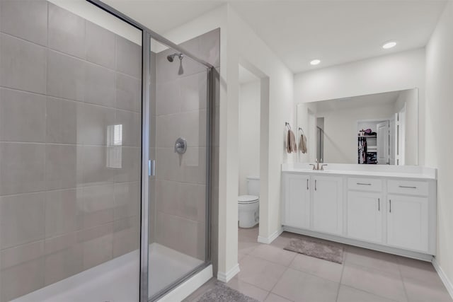 full bath featuring toilet, tile patterned flooring, a walk in closet, vanity, and a shower stall