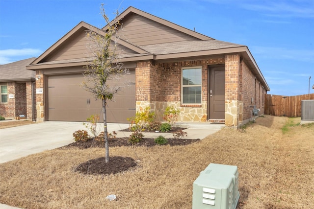 view of front of property with a garage, brick siding, driveway, and fence