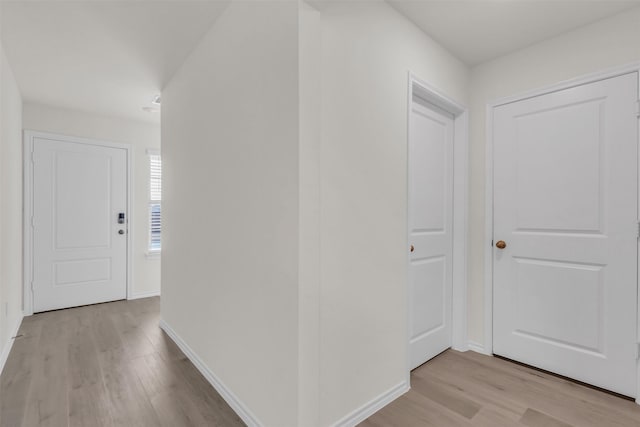 corridor featuring baseboards and light wood-style floors