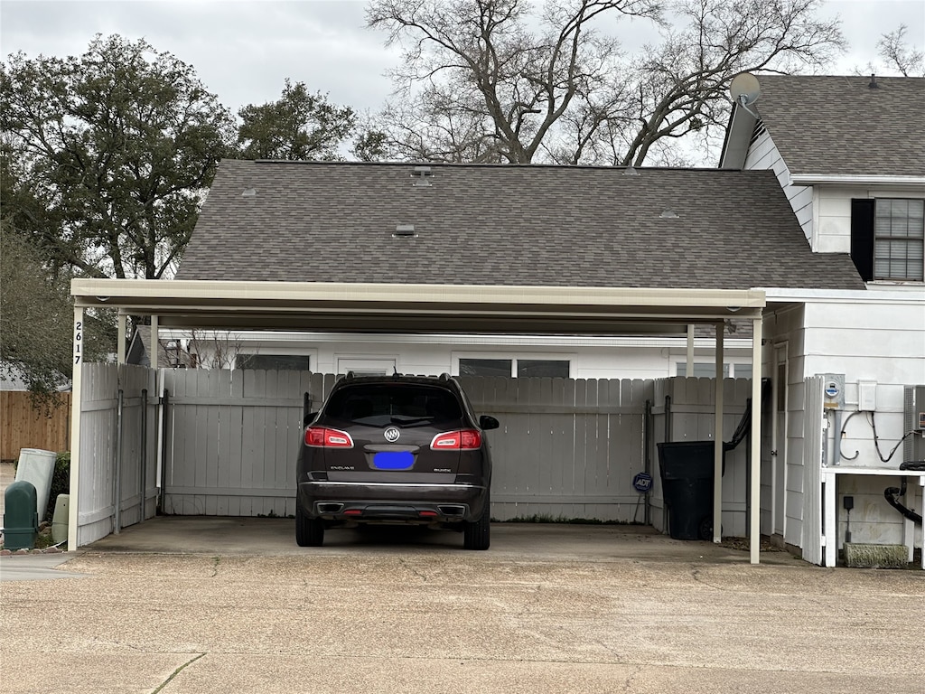 garage featuring driveway and fence