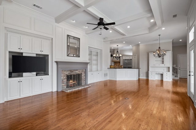 unfurnished living room featuring visible vents, a stone fireplace, wood finished floors, beamed ceiling, and ceiling fan with notable chandelier