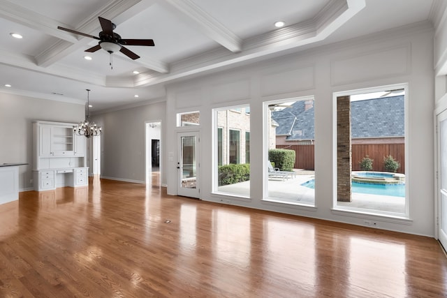 unfurnished living room with ceiling fan with notable chandelier, ornamental molding, beamed ceiling, and light wood-type flooring