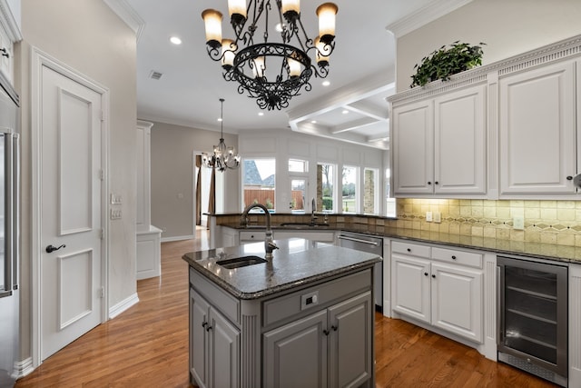 kitchen featuring wine cooler, ornamental molding, backsplash, stainless steel dishwasher, and a sink